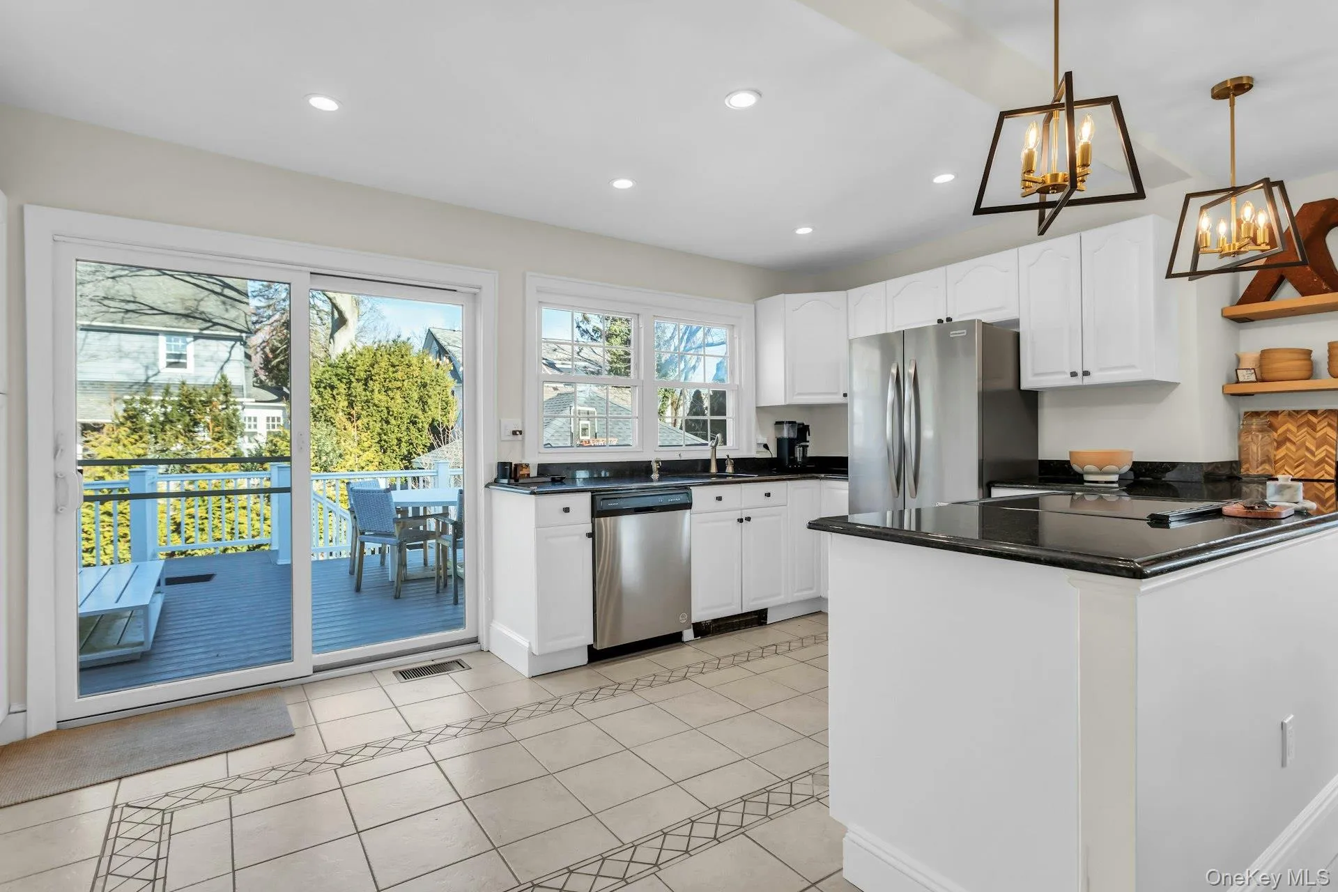 Kitchen with white cabinetry, a peninsula, light tile patterned floors, pendant lighting, and recessed lighting Kitchen with white cabinetry, a peninsula, light tile patterned floors, pendant lighting, and recessed lighting