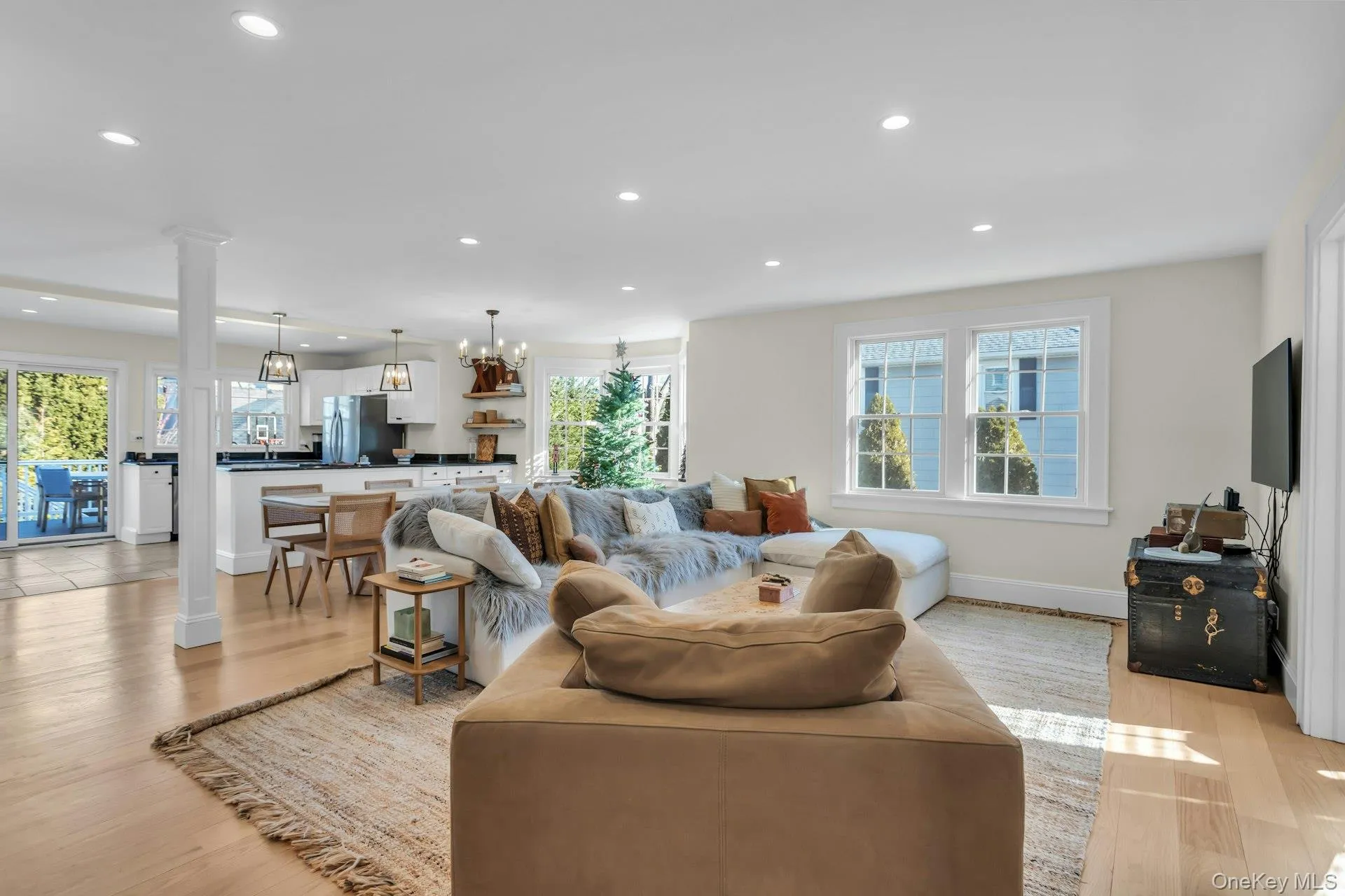 Living area featuring recessed lighting, ornate columns, light wood finished floors, and a chandelier Living area featuring recessed lighting, ornate columns, light wood finished floors, and a chandelier