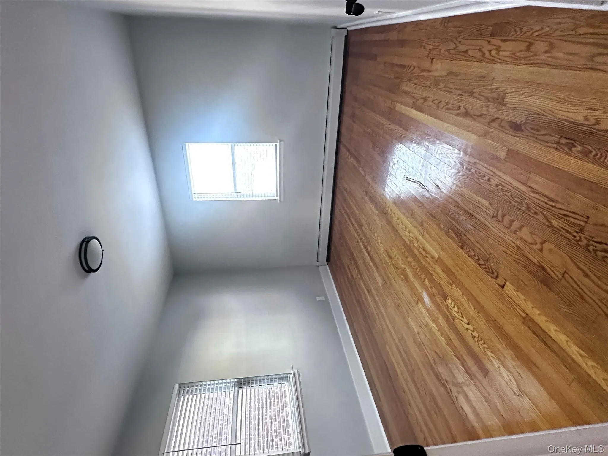 Unfurnished room with light wood finished floors, baseboard heating, and plenty of natural light Unfurnished room with light wood finished floors, baseboard heating, and plenty of natural light