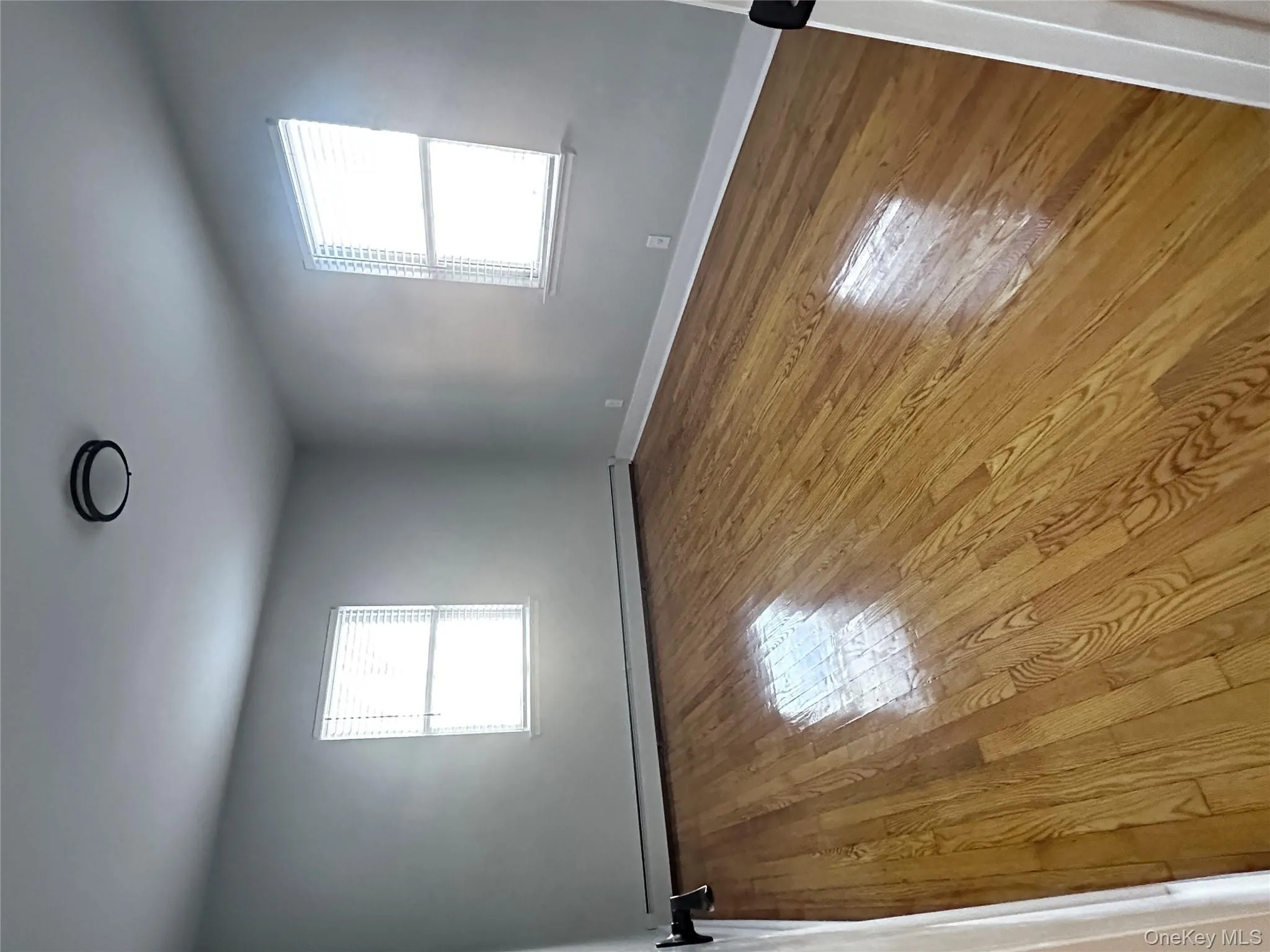 Unfurnished room featuring healthy amount of natural light, baseboard heating, and light wood finished floors Unfurnished room featuring healthy amount of natural light, baseboard heating, and light wood finished floors