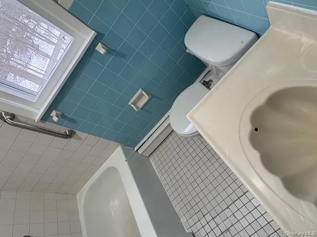 Full bath with tile walls and a bathtub Full bath with tile walls and a bathtub