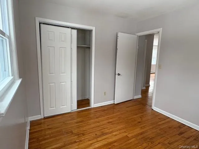 Unfurnished bedroom featuring hardwood / wood-style flooring and a closet Unfurnished bedroom featuring hardwood / wood-style flooring and a closet