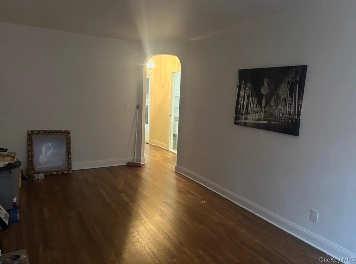 Empty room featuring arched walkways and dark wood finished floors Empty room featuring arched walkways and dark wood finished floors