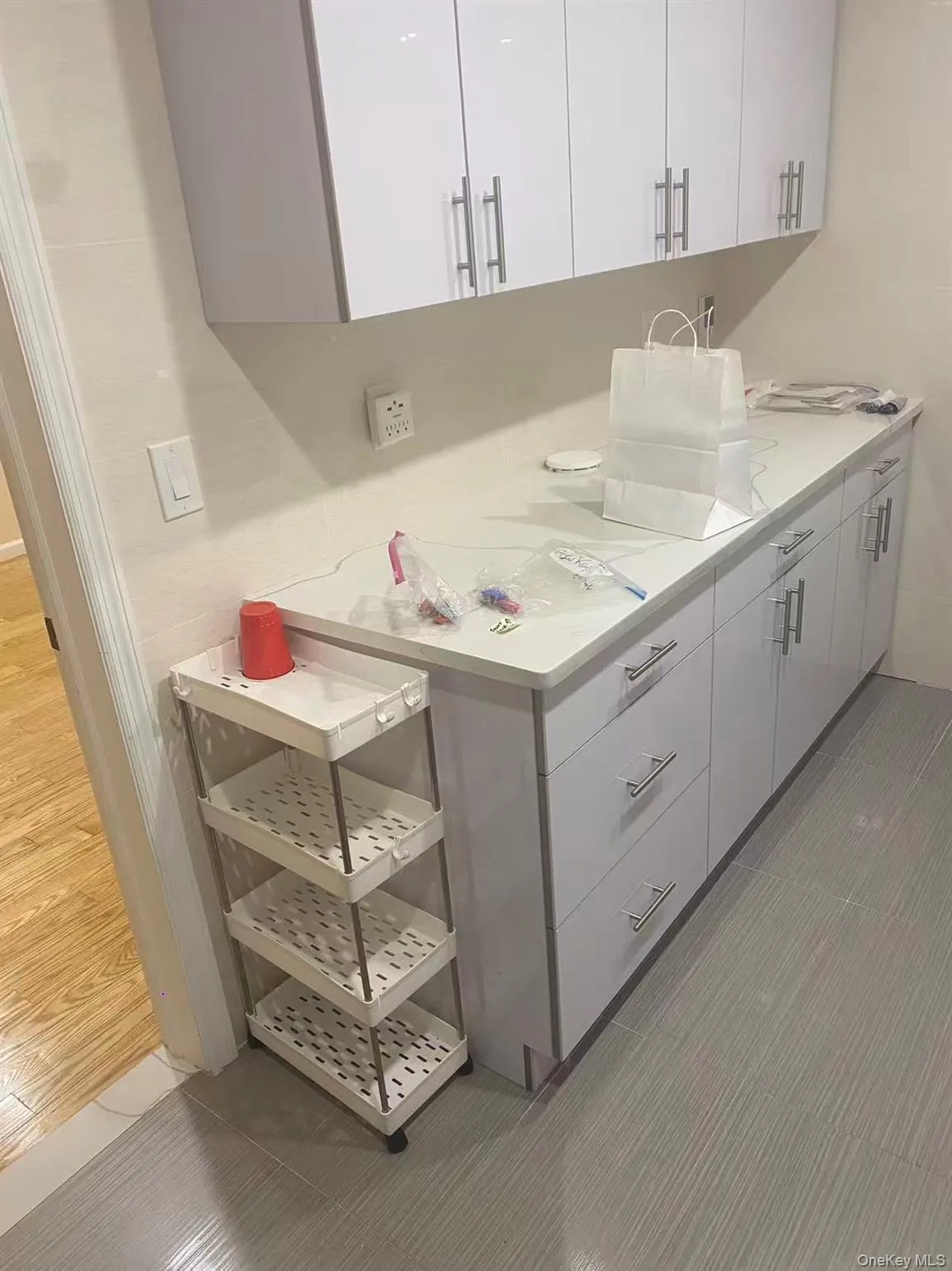 Kitchen featuring light countertops, white cabinetry, and light tile patterned floors Kitchen featuring light countertops, white cabinetry, and light tile patterned floors