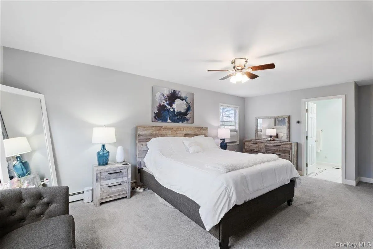 Bedroom featuring carpet flooring, ceiling fan, and ensuite bathroom Bedroom featuring carpet flooring, ceiling fan, and ensuite bathroom