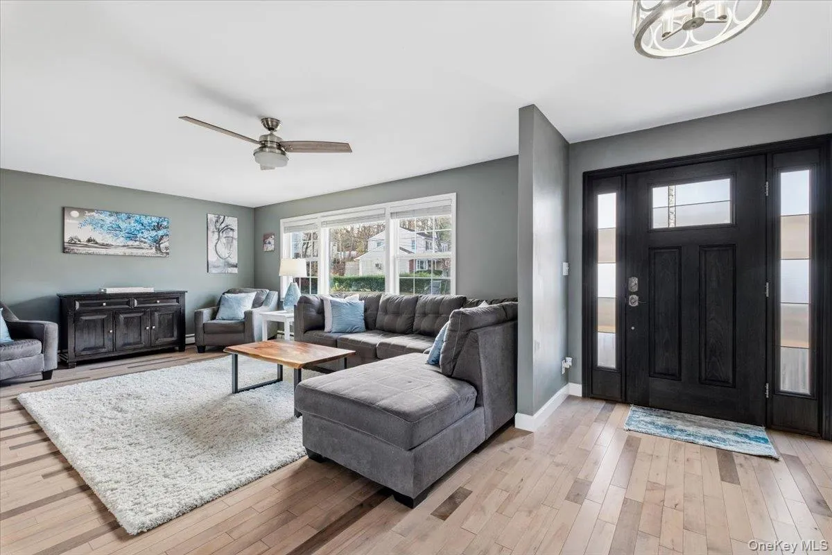 Living room with light wood finished floors and a ceiling fan Living room with light wood finished floors and a ceiling fan