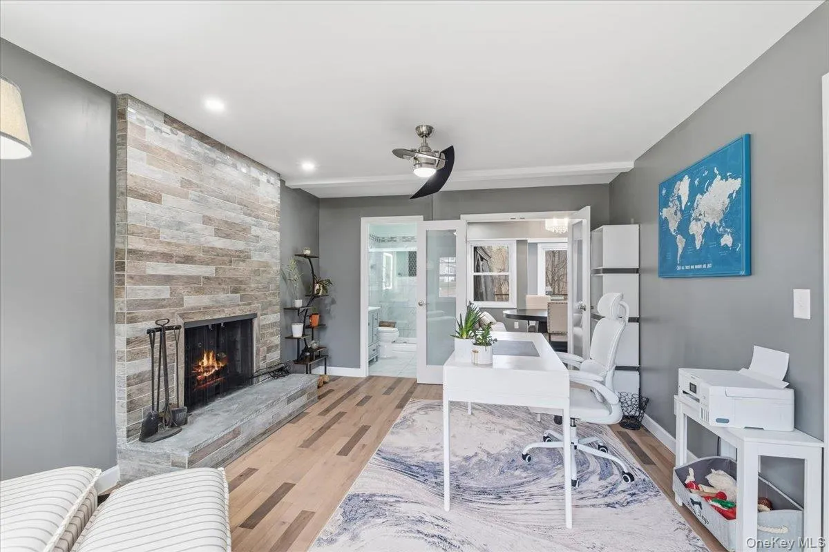 Office space with a fireplace and wood finished floors Office space with a fireplace and wood finished floors