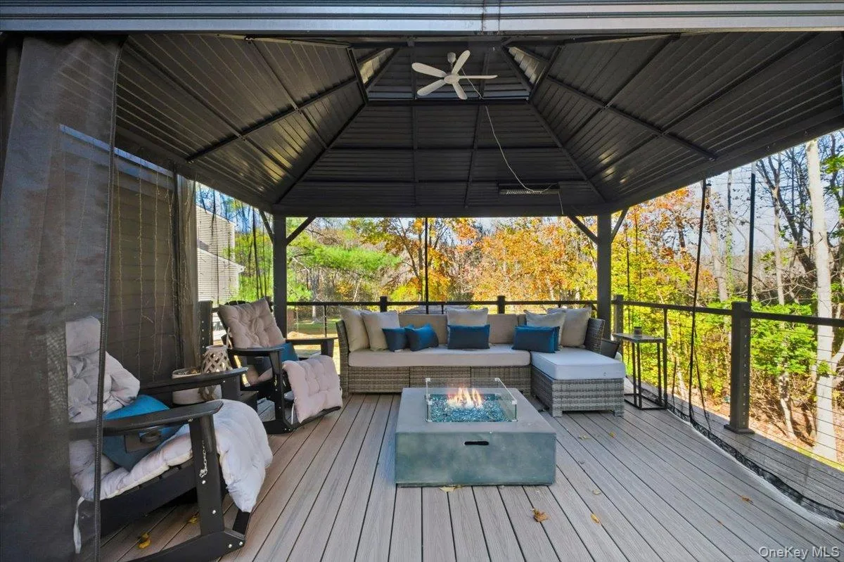 Deck featuring an outdoor living space with a fire pit and a gazebo Deck featuring an outdoor living space with a fire pit and a gazebo