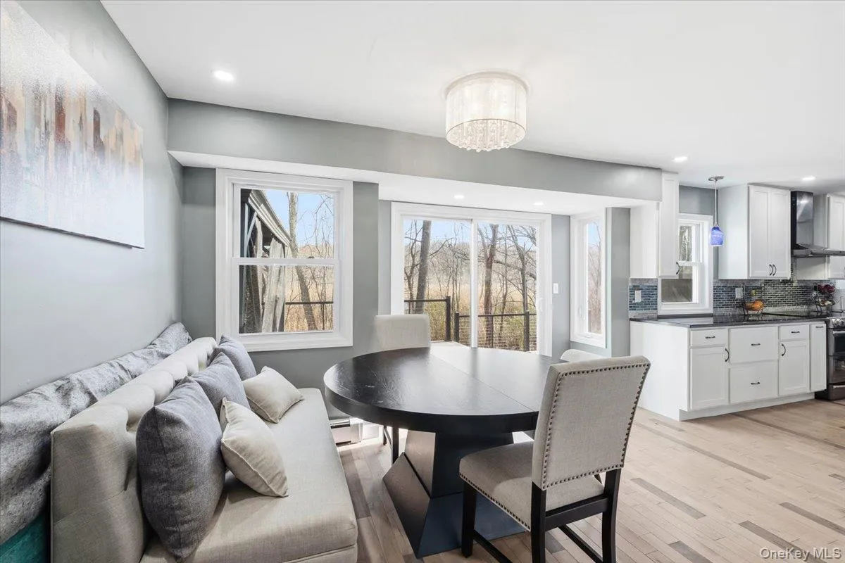 Dining space featuring light wood-type flooring, recessed lighting, a chandelier, and a baseboard heating unit Dining space featuring light wood-type flooring, recessed lighting, a chandelier, and a baseboard heating unit