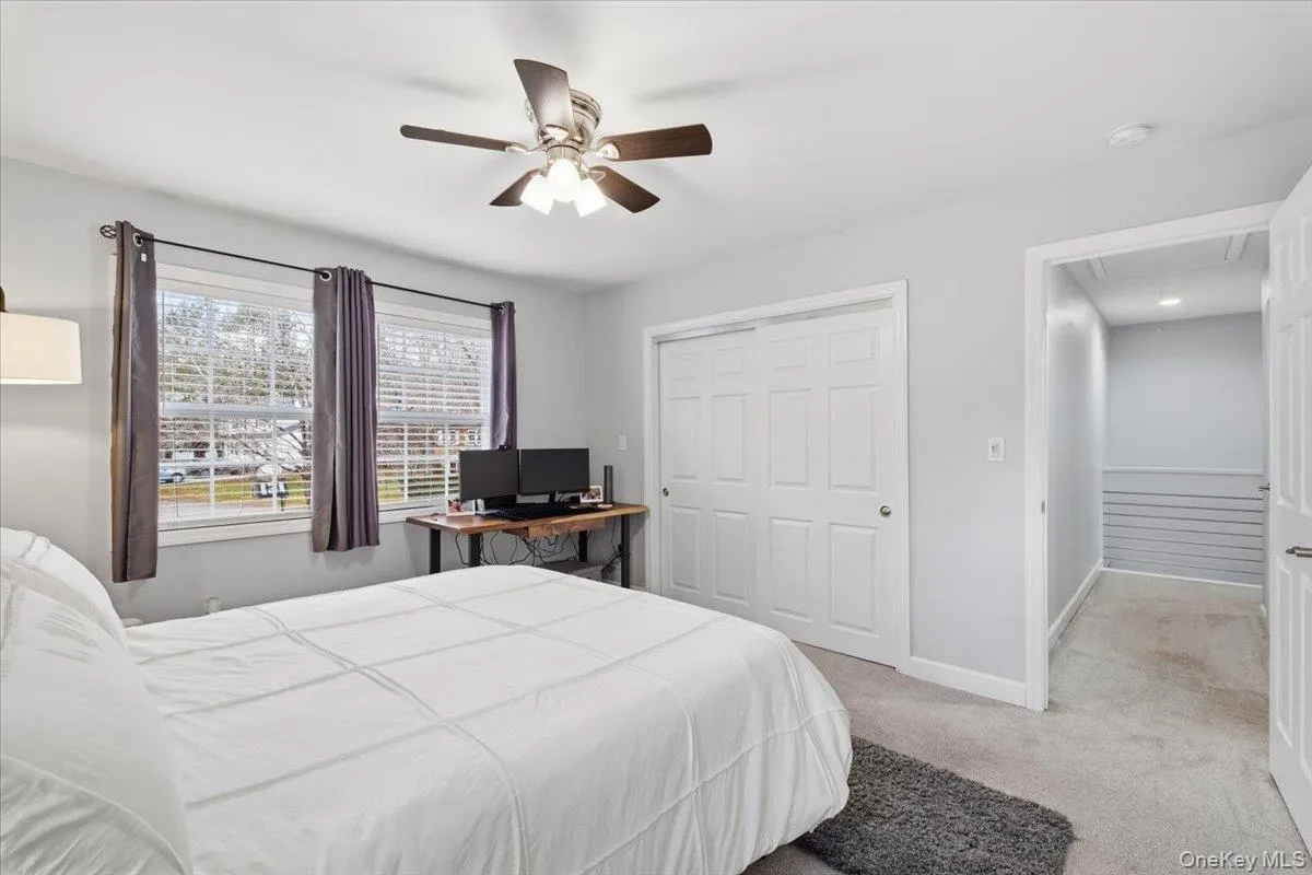 Bedroom featuring light carpet, a closet, and a ceiling fan Bedroom featuring light carpet, a closet, and a ceiling fan