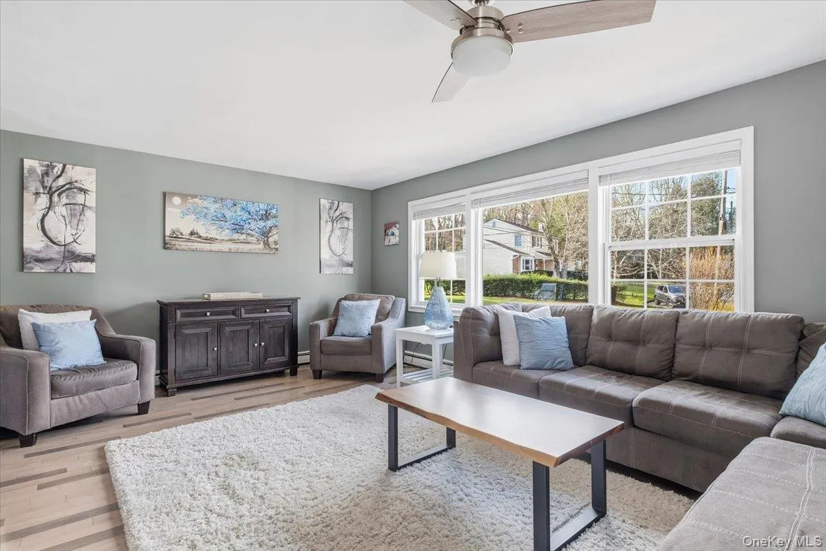 Living area featuring light wood-style flooring and a ceiling fan Living area featuring light wood-style flooring and a ceiling fan