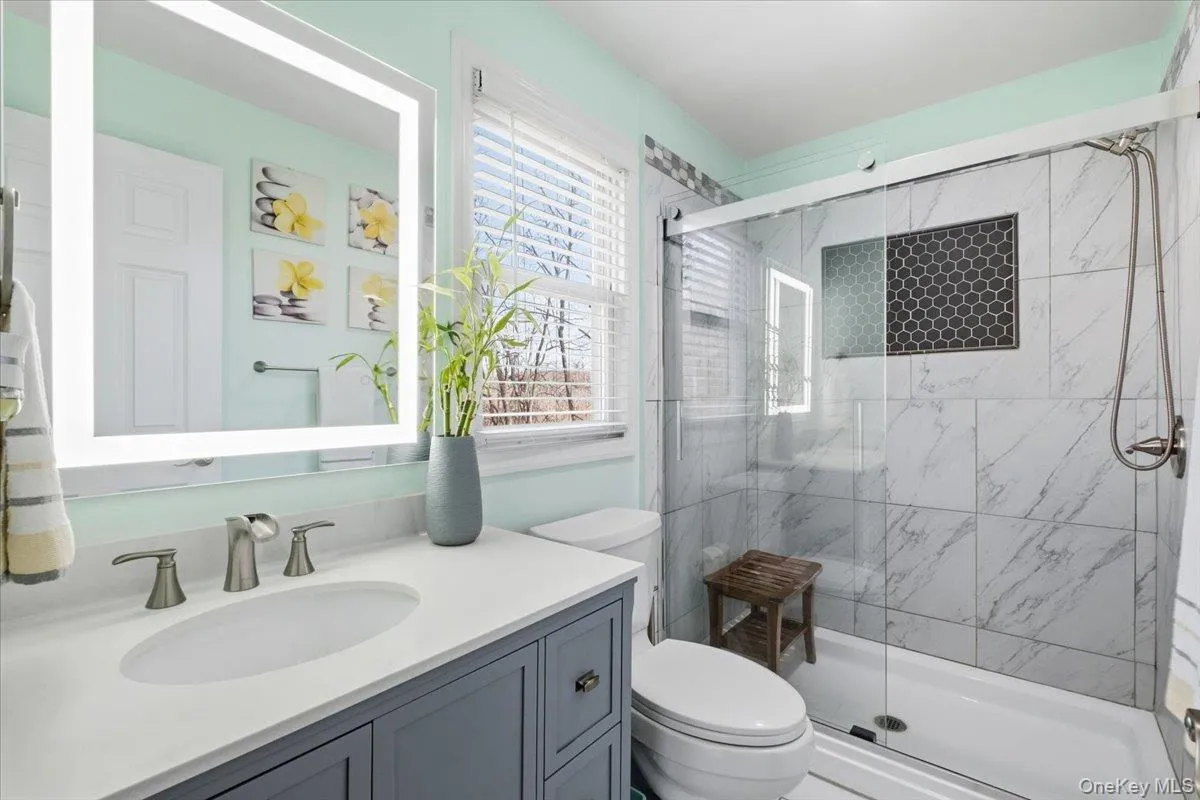 Bathroom with a marble finish shower and vanity Bathroom with a marble finish shower and vanity