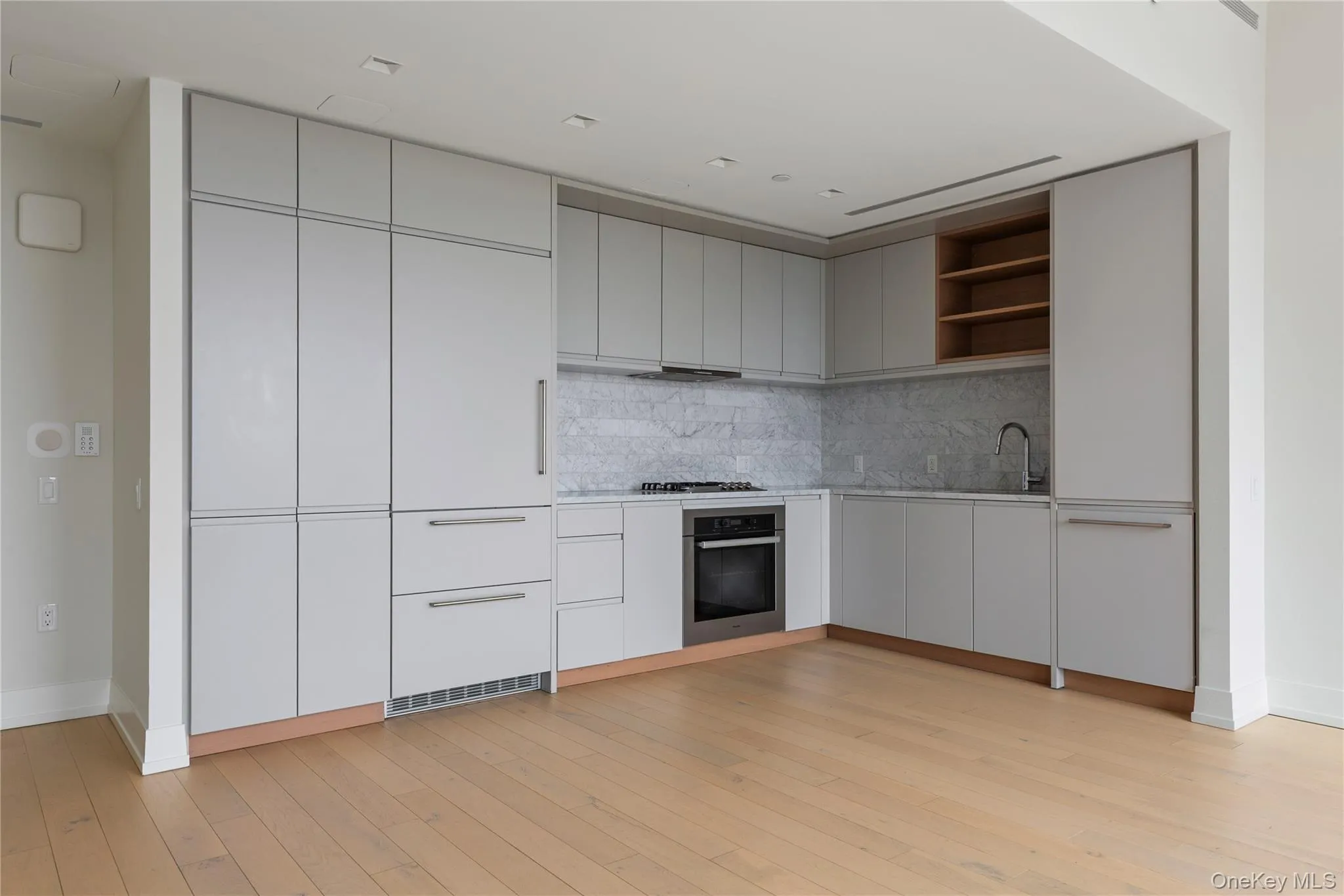 Kitchen featuring open shelves, modern cabinets, stainless steel appliances, tasteful backsplash, and light wood-type flooring Kitchen featuring open shelves, modern cabinets, stainless steel appliances, tasteful backsplash, and light wood-type flooring