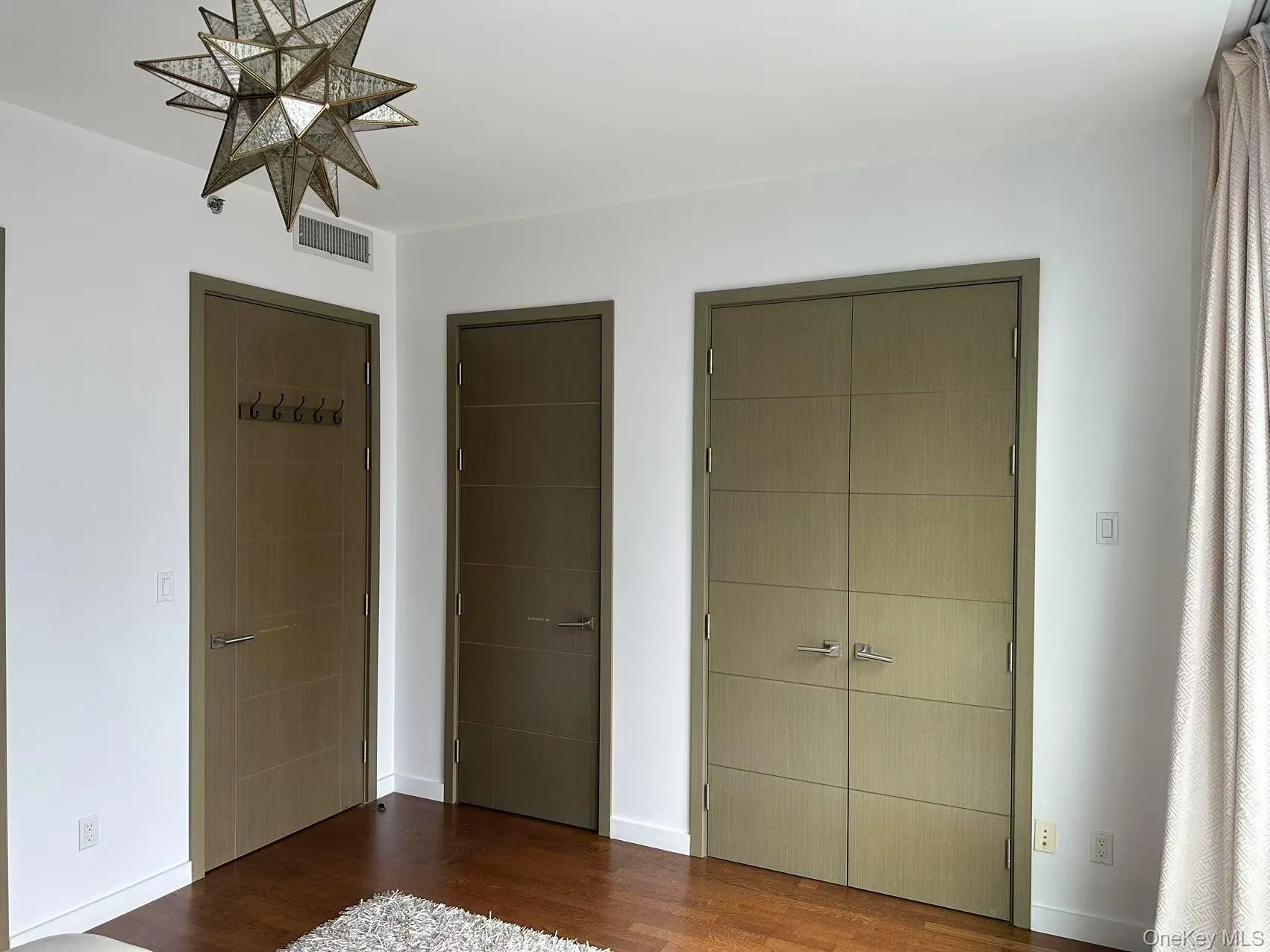 Unfurnished bedroom featuring multiple closets and wood finished floors Unfurnished bedroom featuring multiple closets and wood finished floors