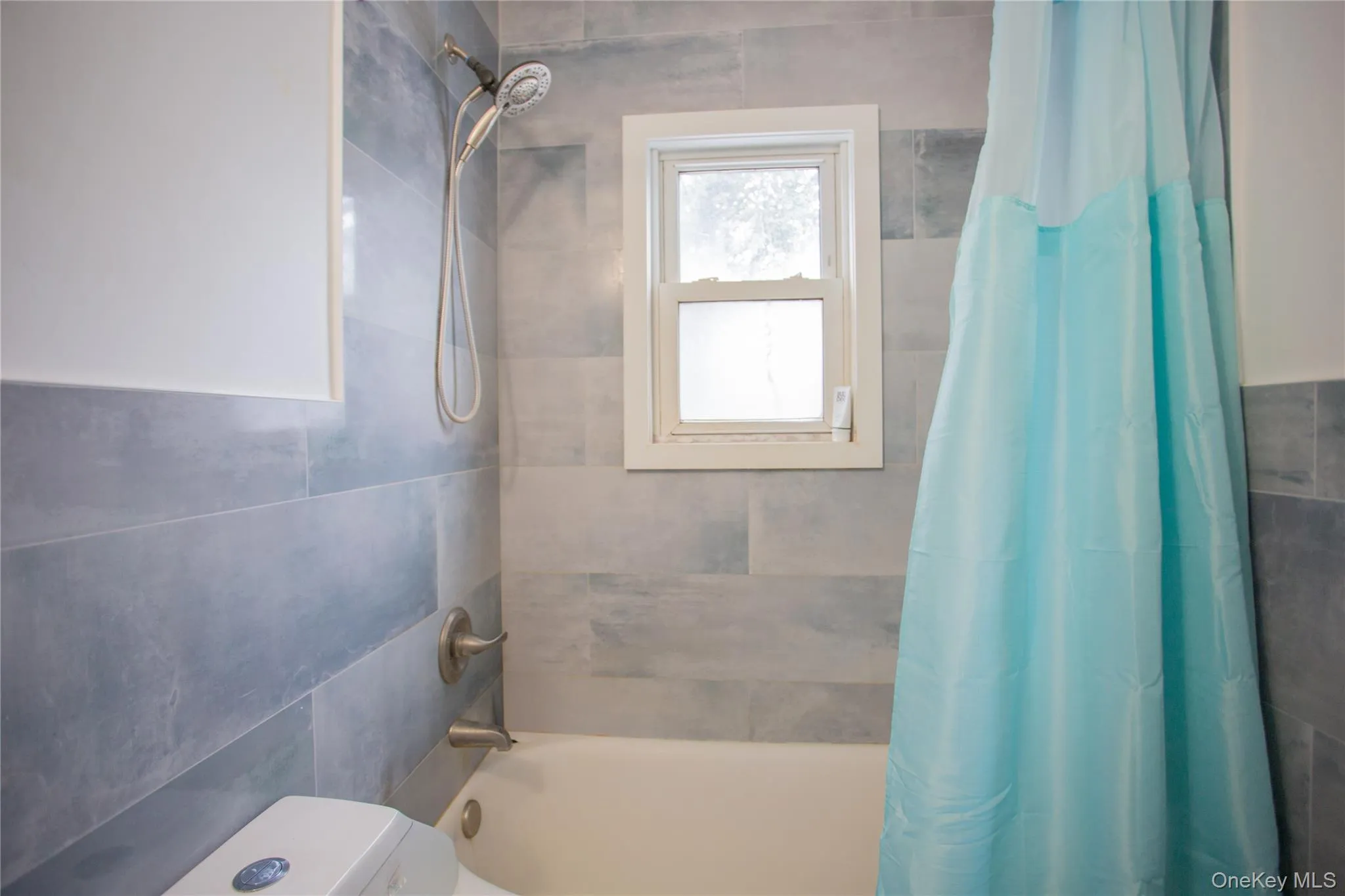 Bathroom with shower / bath combination with curtain and tile walls Bathroom with shower / bath combination with curtain and tile walls