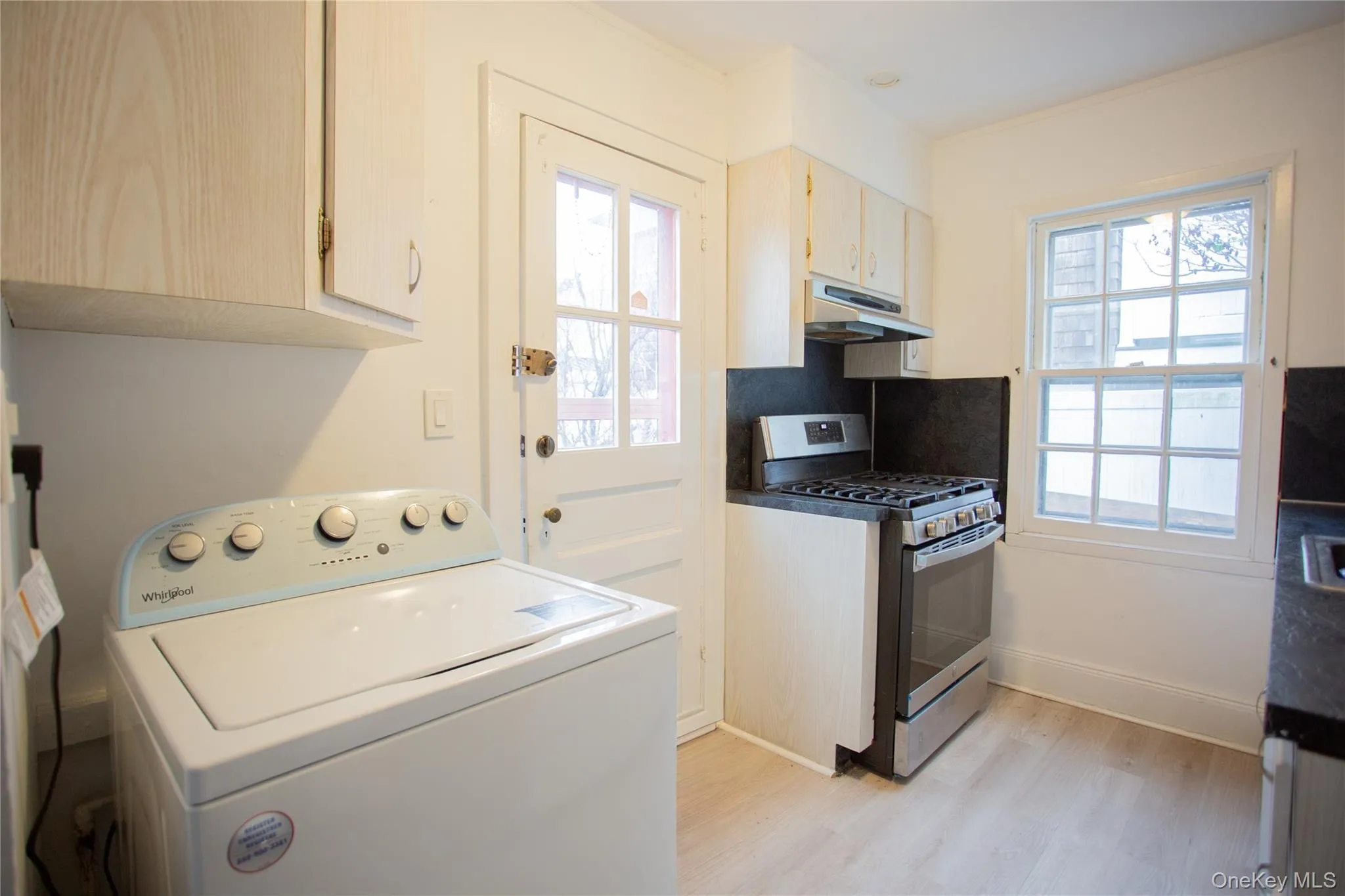 Washroom featuring washer / dryer and light wood-style flooring Washroom featuring washer / dryer and light wood-style flooring