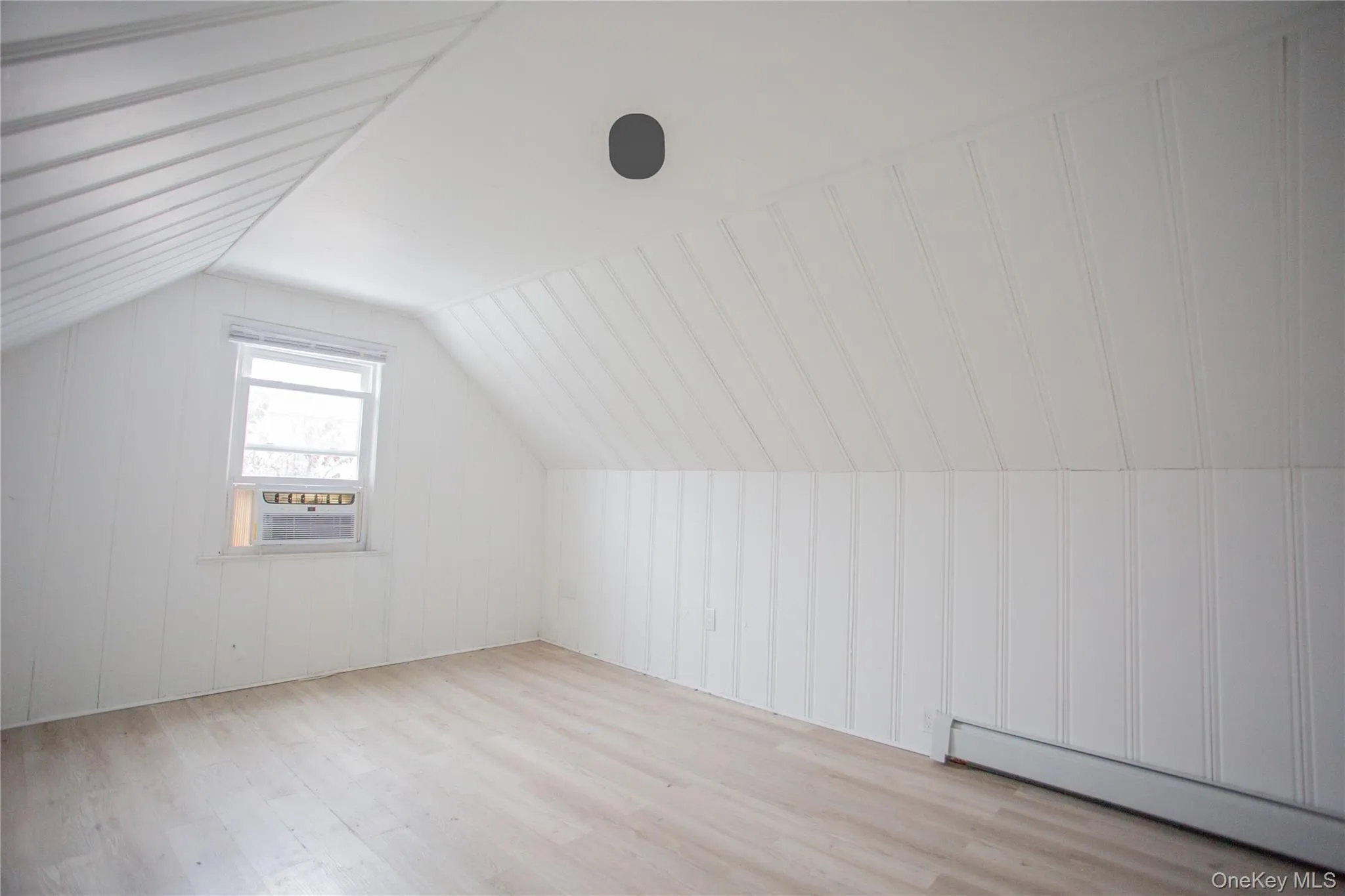 Bonus room with light wood-style floors, a baseboard heating unit, and vaulted ceiling Bonus room with light wood-style floors, a baseboard heating unit, and vaulted ceiling