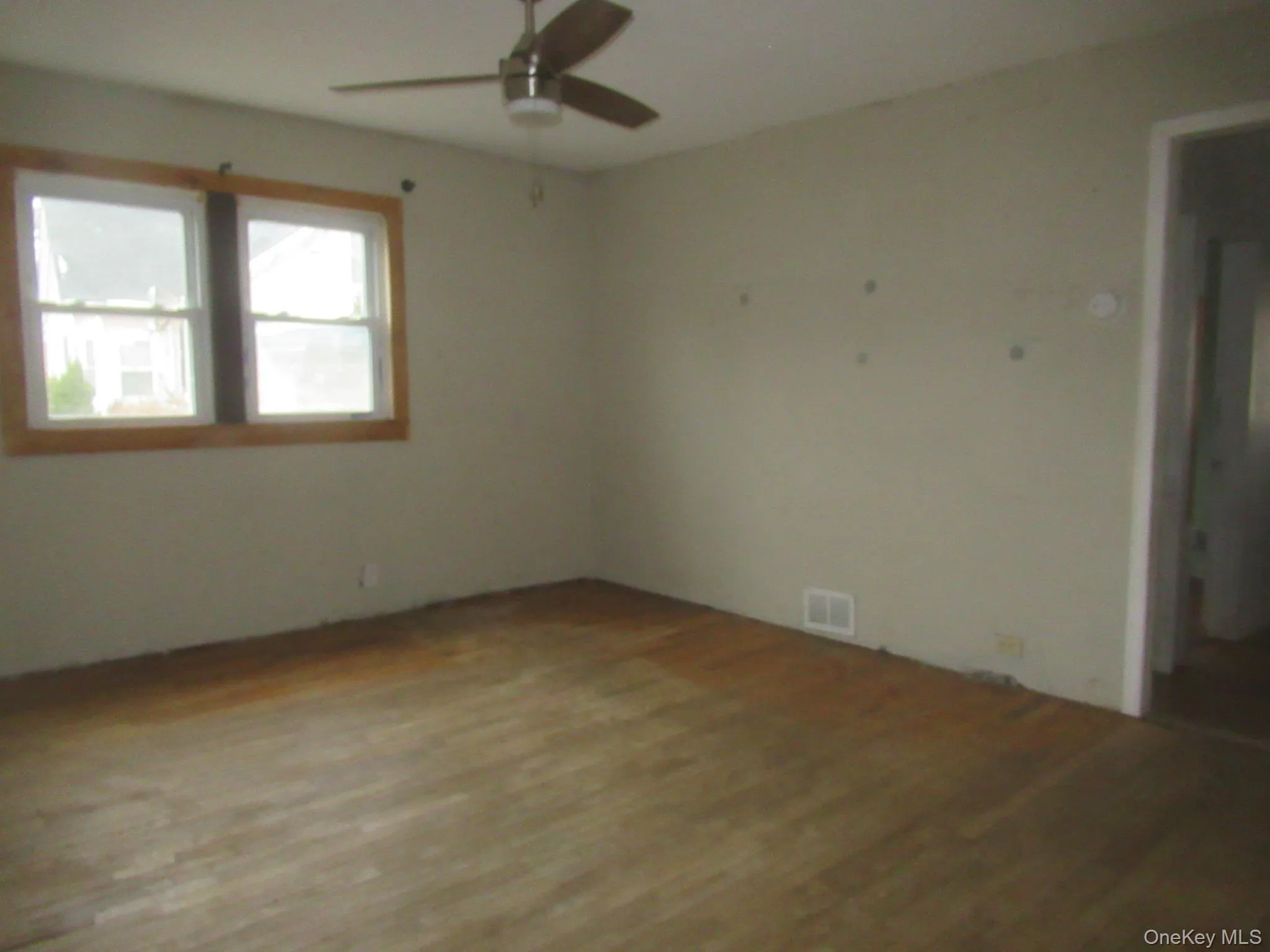 Empty room with wood finished floors and a ceiling fan Empty room with wood finished floors and a ceiling fan