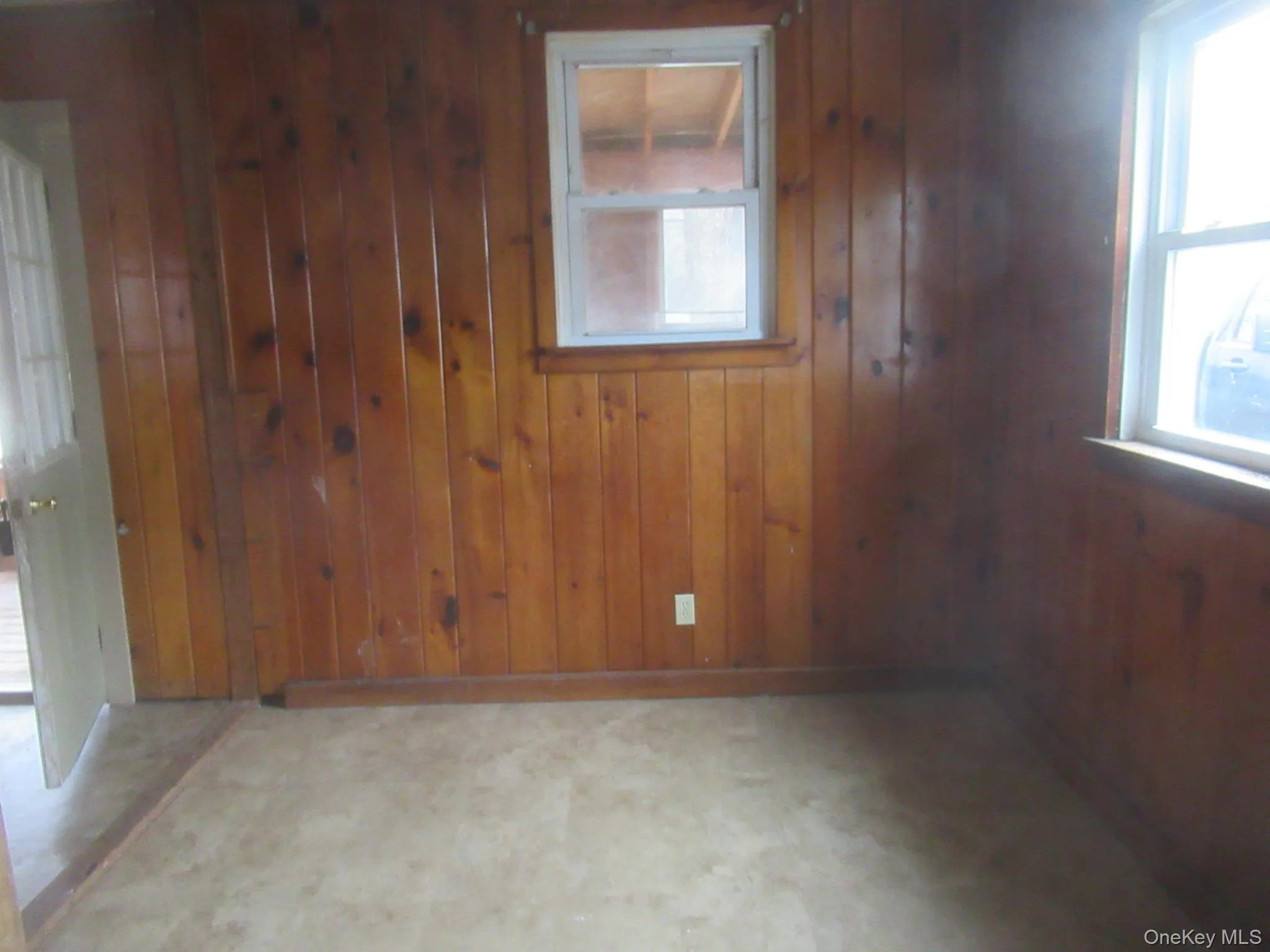 Empty room featuring wooden walls and tile patterned floors Empty room featuring wooden walls and tile patterned floors