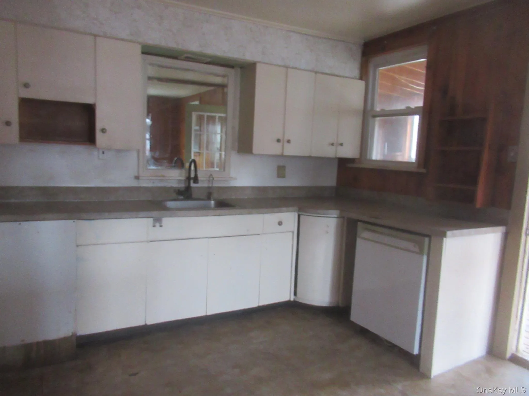Kitchen with white dishwasher, open shelves, plenty of natural light, and white cabinets Kitchen with white dishwasher, open shelves, plenty of natural light, and white cabinets