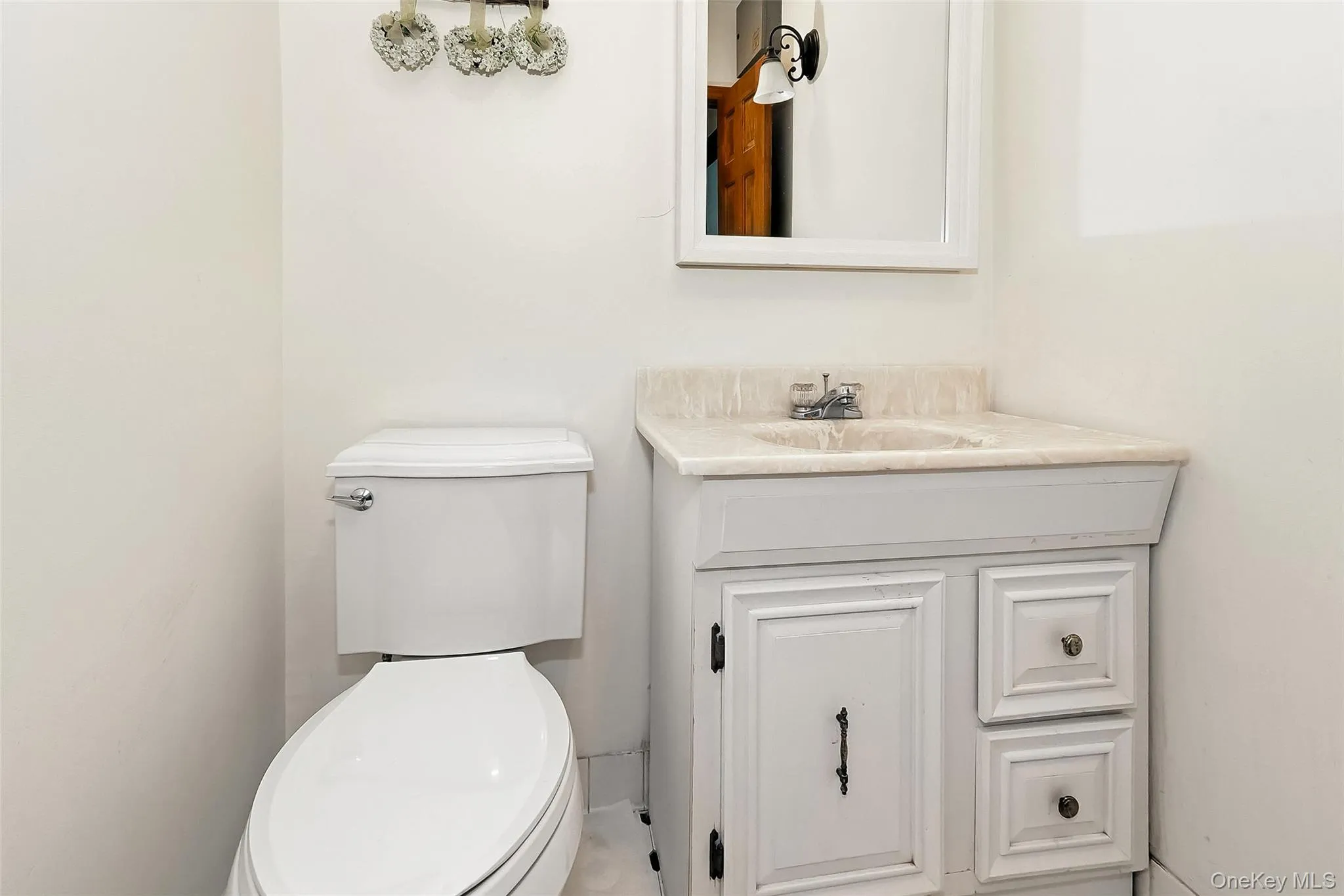 Half bath featuring vanity and toilet Half bath featuring vanity and toilet