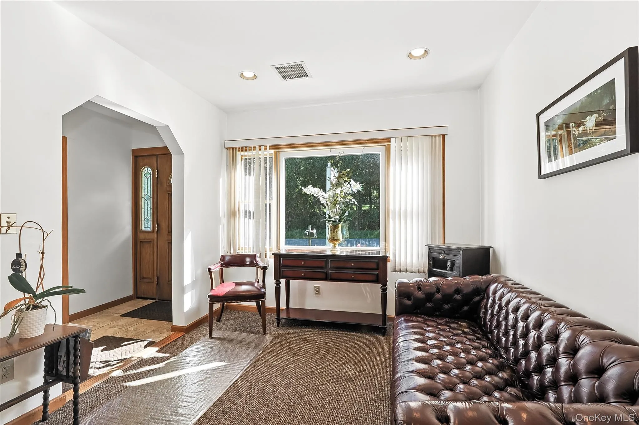 Carpeted living room featuring arched walkways and recessed lighting Carpeted living room featuring arched walkways and recessed lighting