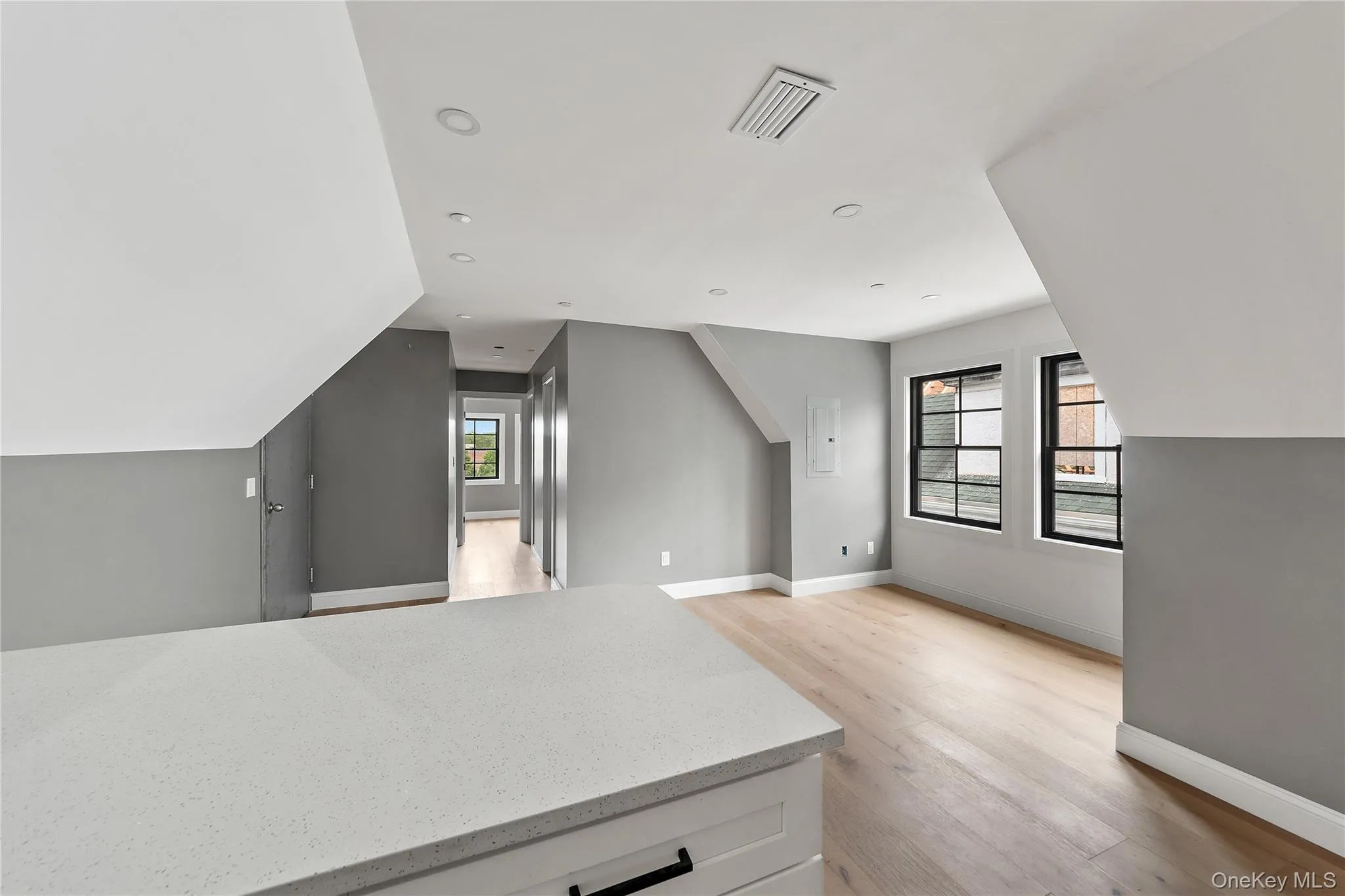 Kitchen featuring light wood-style floors, white cabinetry, light stone countertops, plenty of natural light, and recessed lighting Kitchen featuring light wood-style floors, white cabinetry, light stone countertops, plenty of natural light, and recessed lighting