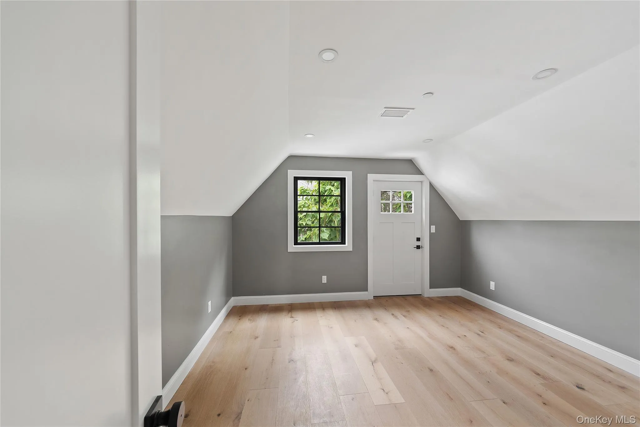 Bonus room featuring light wood-type flooring and vaulted ceiling Bonus room featuring light wood-type flooring and vaulted ceiling