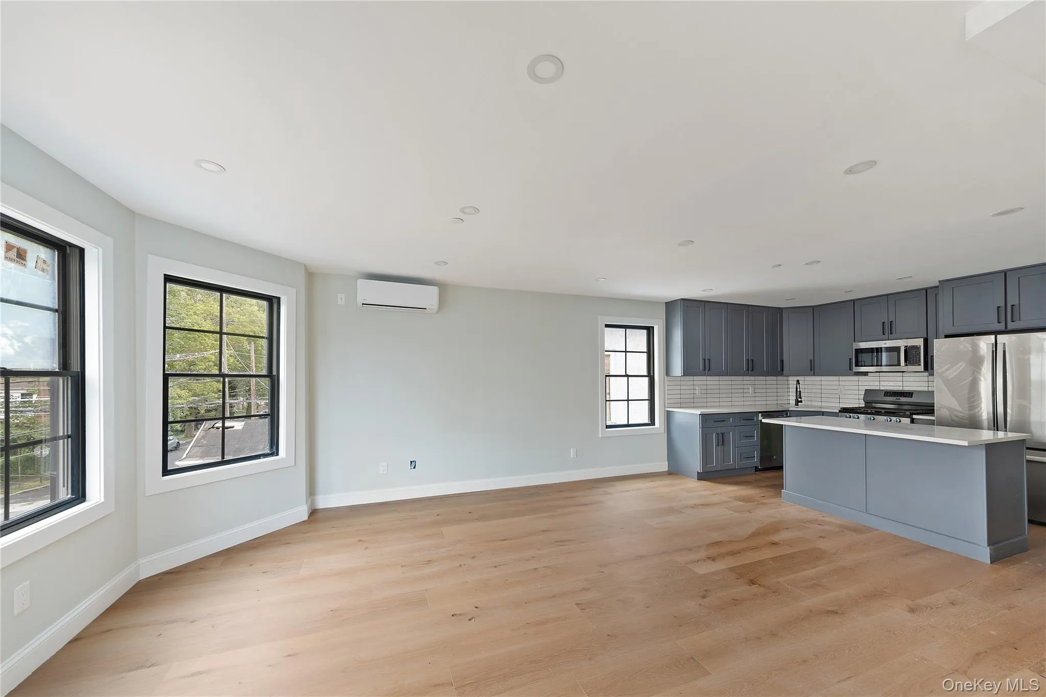 Kitchen featuring stainless steel appliances, gray cabinetry, light wood-type flooring, and recessed lighting Kitchen featuring stainless steel appliances, gray cabinetry, light wood-type flooring, and recessed lighting