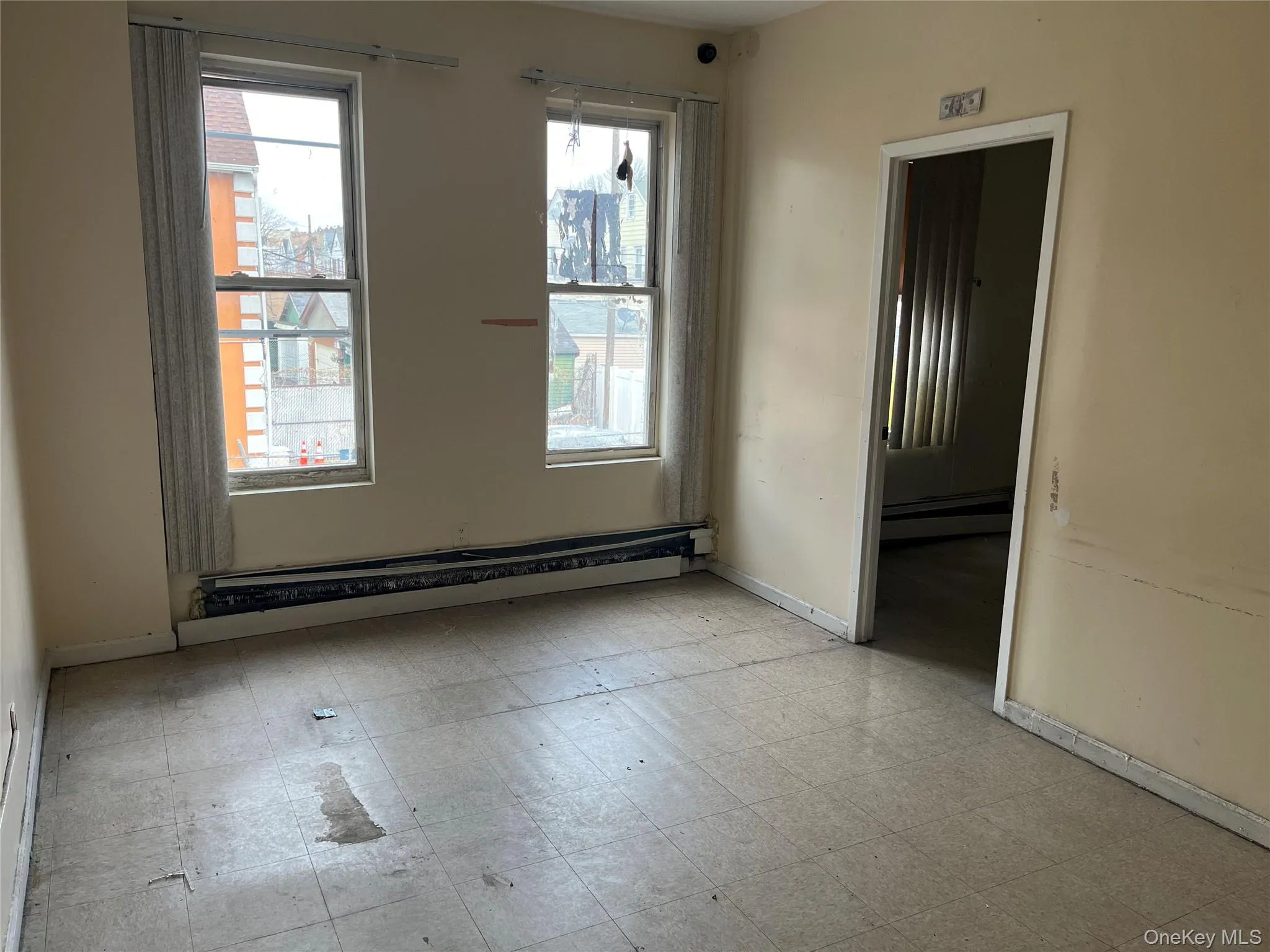 Spare room featuring light floors and a baseboard heating unit Spare room featuring light floors and a baseboard heating unit