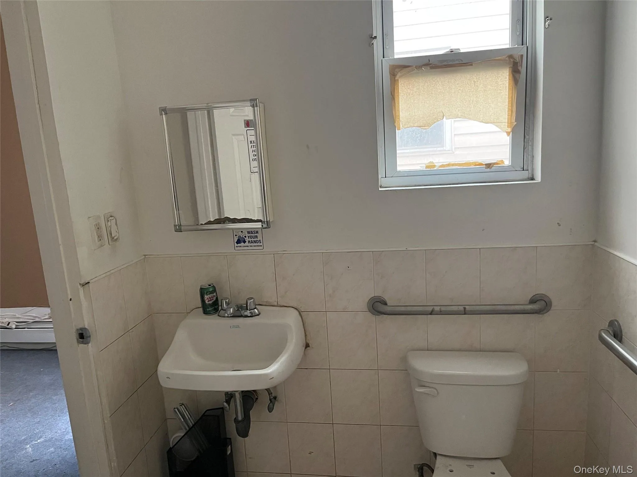 Half bathroom with a wainscoted wall and tile walls Half bathroom with a wainscoted wall and tile walls