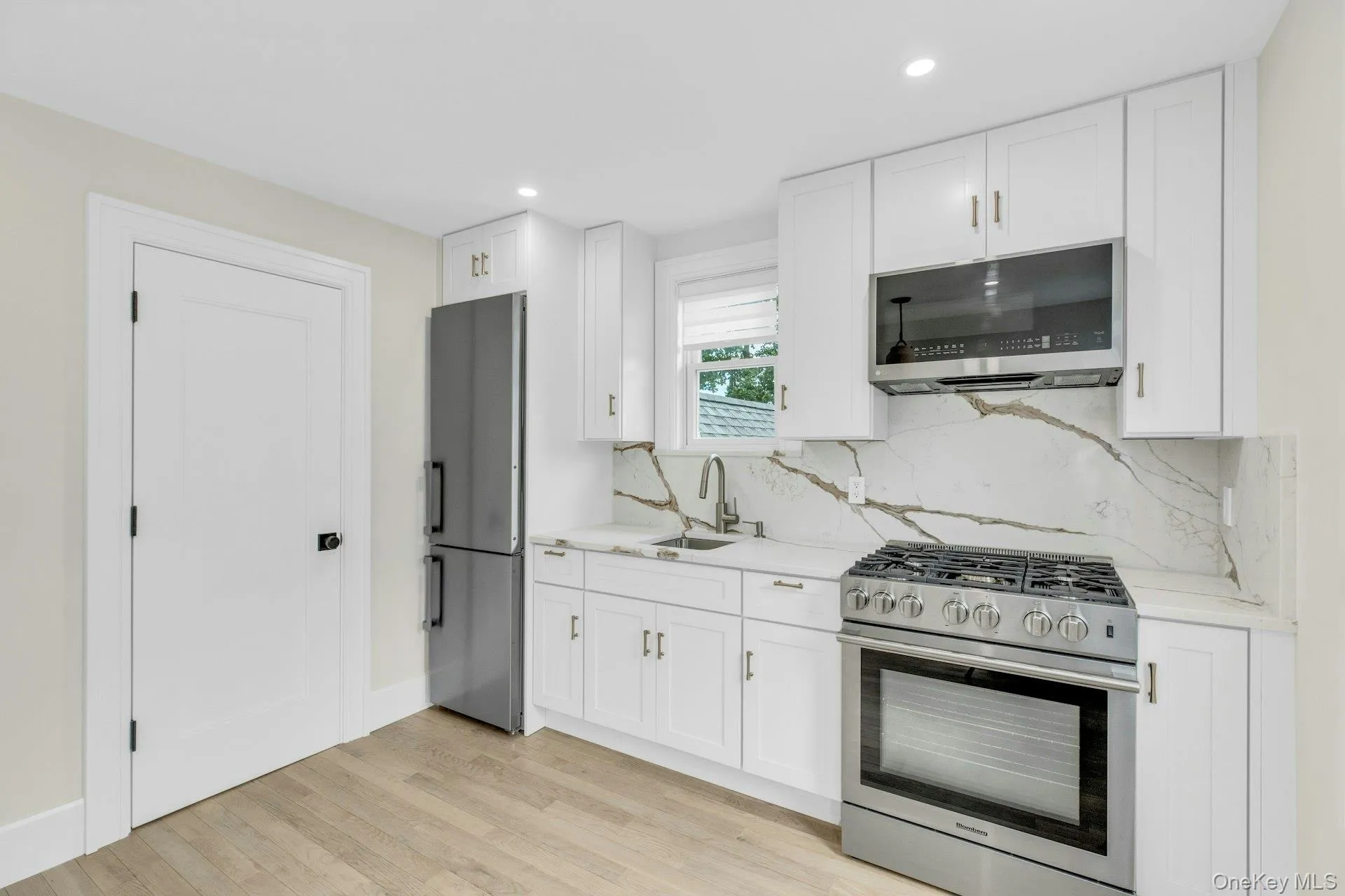 Kitchen featuring appliances with stainless steel finishes, white cabinets, light wood-style floors, and recessed lighting Kitchen featuring appliances with stainless steel finishes, white cabinets, light wood-style floors, and recessed lighting