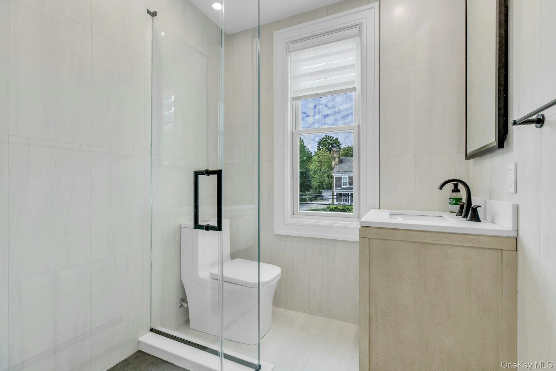 Full bathroom with vanity, a shower stall, and tile walls Full bathroom with vanity, a shower stall, and tile walls
