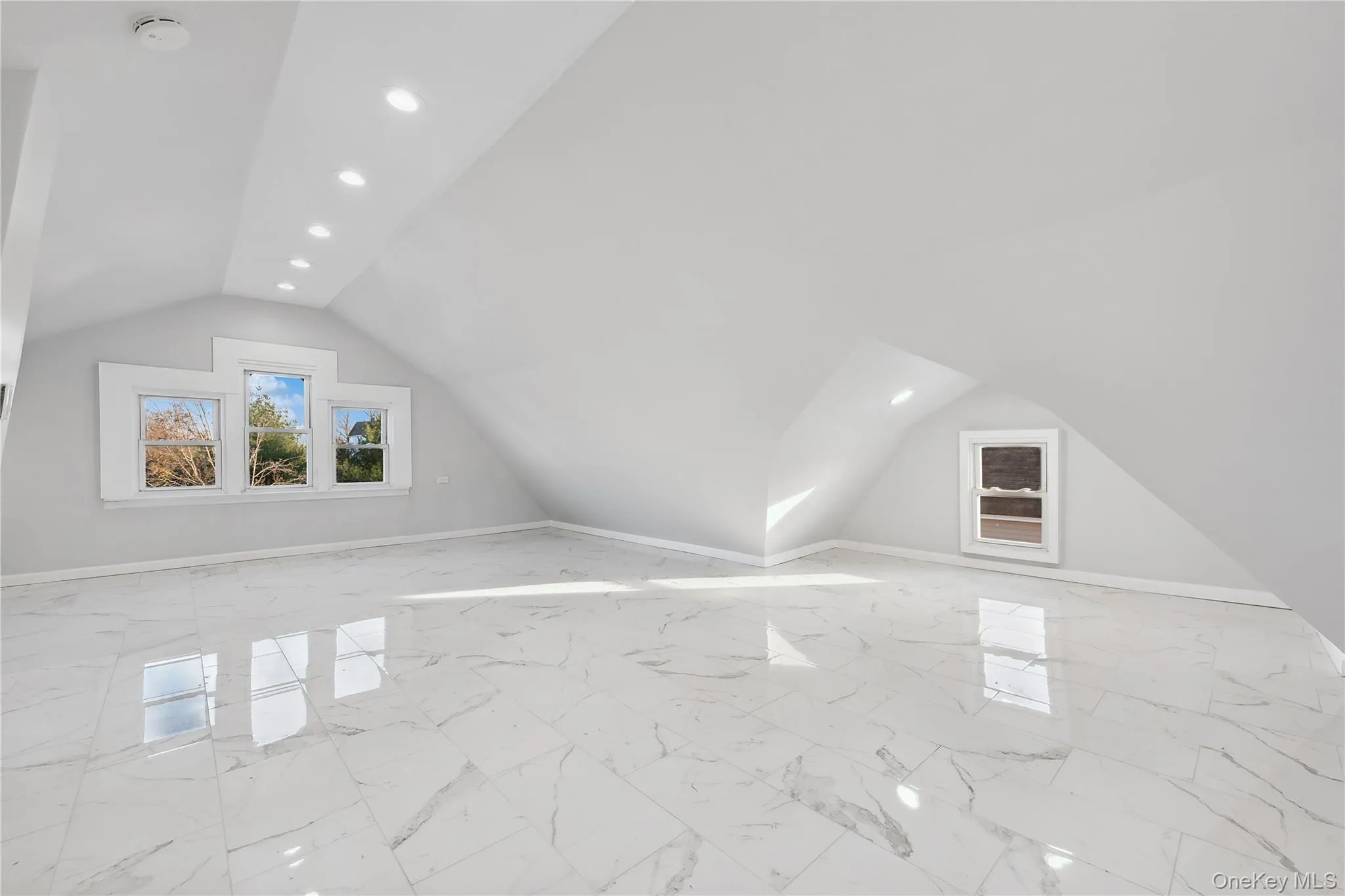 Recessed lighting, vaulted ceiling, and light marble finish flooring Recessed lighting, vaulted ceiling, and light marble finish flooring