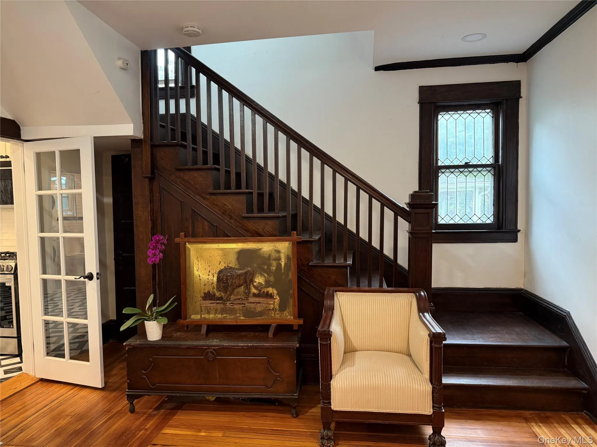 Staircase featuring wood finished floors and ornamental molding Staircase featuring wood finished floors and ornamental molding