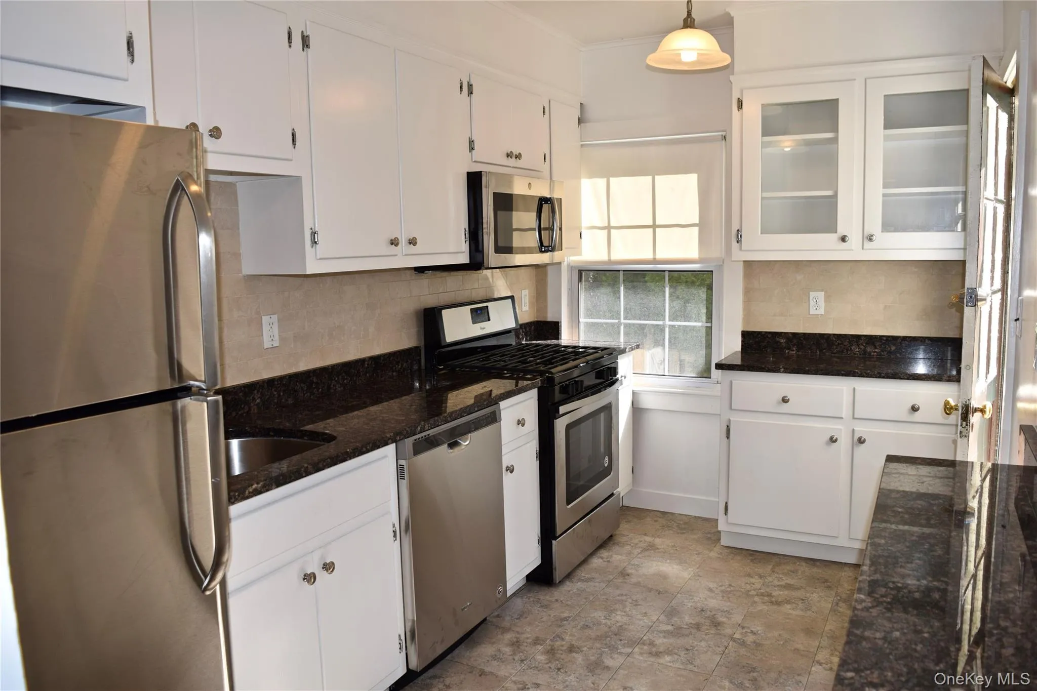 Updated kitchen with stainless steel appliances and exterior door to grilling area. Updated kitchen with stainless steel appliances and exterior door to grilling area.