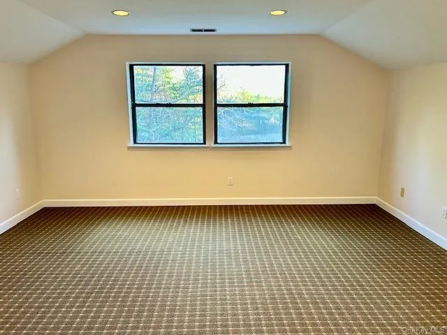 Additional living space featuring vaulted ceiling, dark carpet, and recessed lighting Additional living space featuring vaulted ceiling, dark carpet, and recessed lighting
