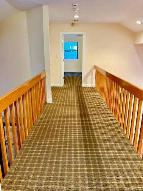 Corridor featuring carpet flooring, vaulted ceiling, an upstairs landing, and recessed lighting Corridor featuring carpet flooring, vaulted ceiling, an upstairs landing, and recessed lighting