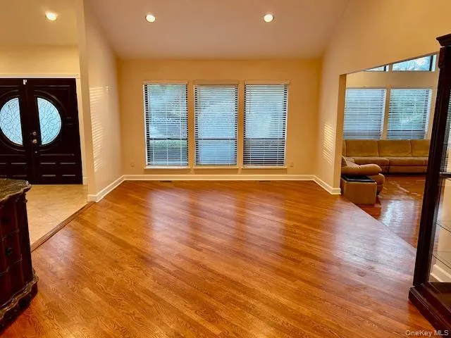 Foyer featuring vaulted ceiling, light wood-style flooring, recessed lighting, and french doors Foyer featuring vaulted ceiling, light wood-style flooring, recessed lighting, and french doors