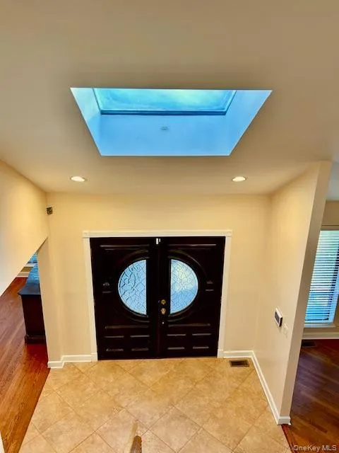 Foyer with light wood finished floors, a skylight, and recessed lighting Foyer with light wood finished floors, a skylight, and recessed lighting