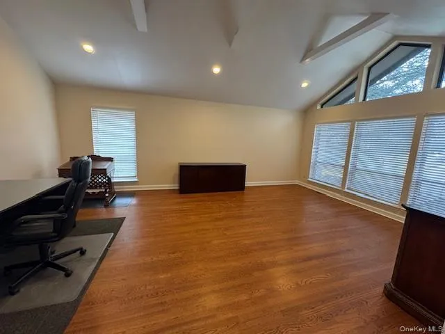 Office space featuring dark wood-style floors, recessed lighting, healthy amount of natural light, and high vaulted ceiling Office space featuring dark wood-style floors, recessed lighting, healthy amount of natural light, and high vaulted ceiling