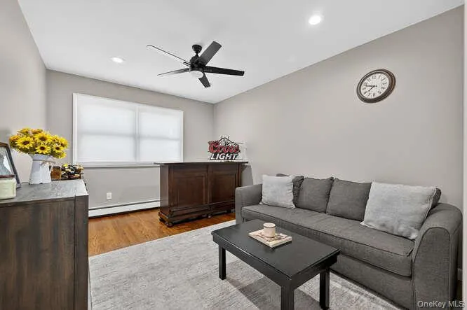 Living area featuring a ceiling fan, light wood-style flooring, baseboard heating, and recessed lighting Living area featuring a ceiling fan, light wood-style flooring, baseboard heating, and recessed lighting