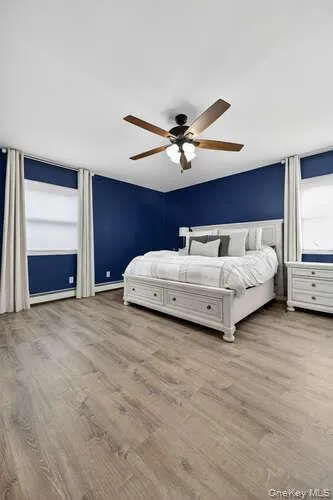 Bedroom featuring ceiling fan and wood finished floors Bedroom featuring ceiling fan and wood finished floors