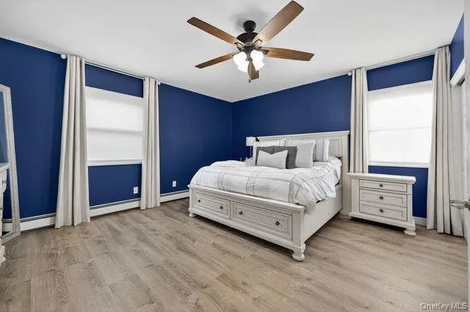 Bedroom with light wood-style flooring and a ceiling fan Bedroom with light wood-style flooring and a ceiling fan