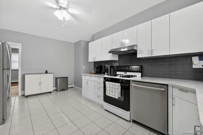 Kitchen featuring stainless steel appliances, white cabinetry, and under cabinet range hood Kitchen featuring stainless steel appliances, white cabinetry, and under cabinet range hood