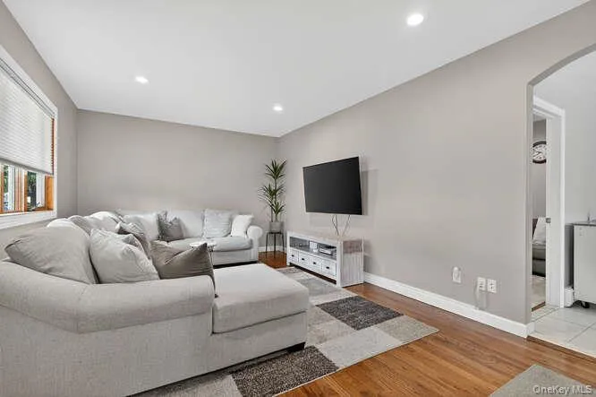 Living area with arched walkways, light wood finished floors, and recessed lighting Living area with arched walkways, light wood finished floors, and recessed lighting