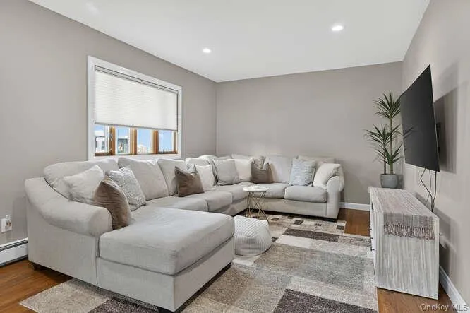 Living area featuring wood finished floors and recessed lighting Living area featuring wood finished floors and recessed lighting