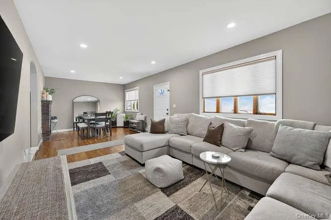 Living area featuring wood finished floors, arched walkways, and recessed lighting Living area featuring wood finished floors, arched walkways, and recessed lighting
