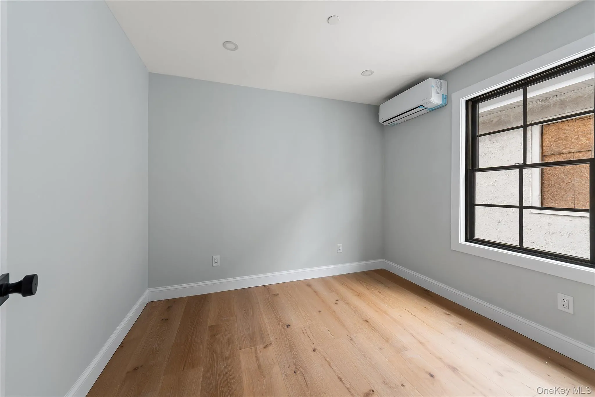 Spare room with light wood-type flooring, a wall mounted AC, and recessed lighting Spare room with light wood-type flooring, a wall mounted AC, and recessed lighting
