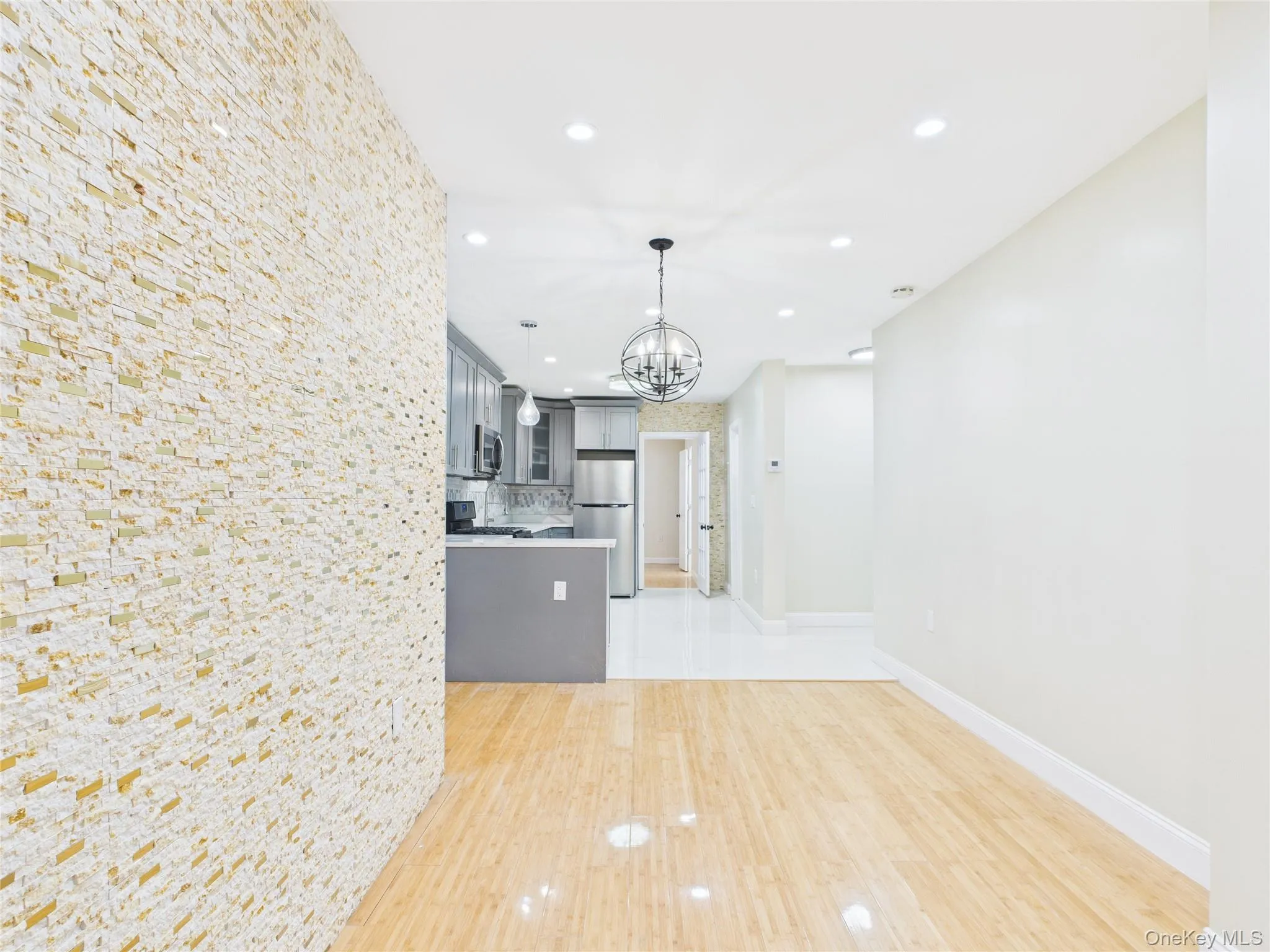 Kitchen with gray cabinetry, recessed lighting, pendant lighting, a chandelier, and appliances with stainless steel finishes Kitchen with gray cabinetry, recessed lighting, pendant lighting, a chandelier, and appliances with stainless steel finishes